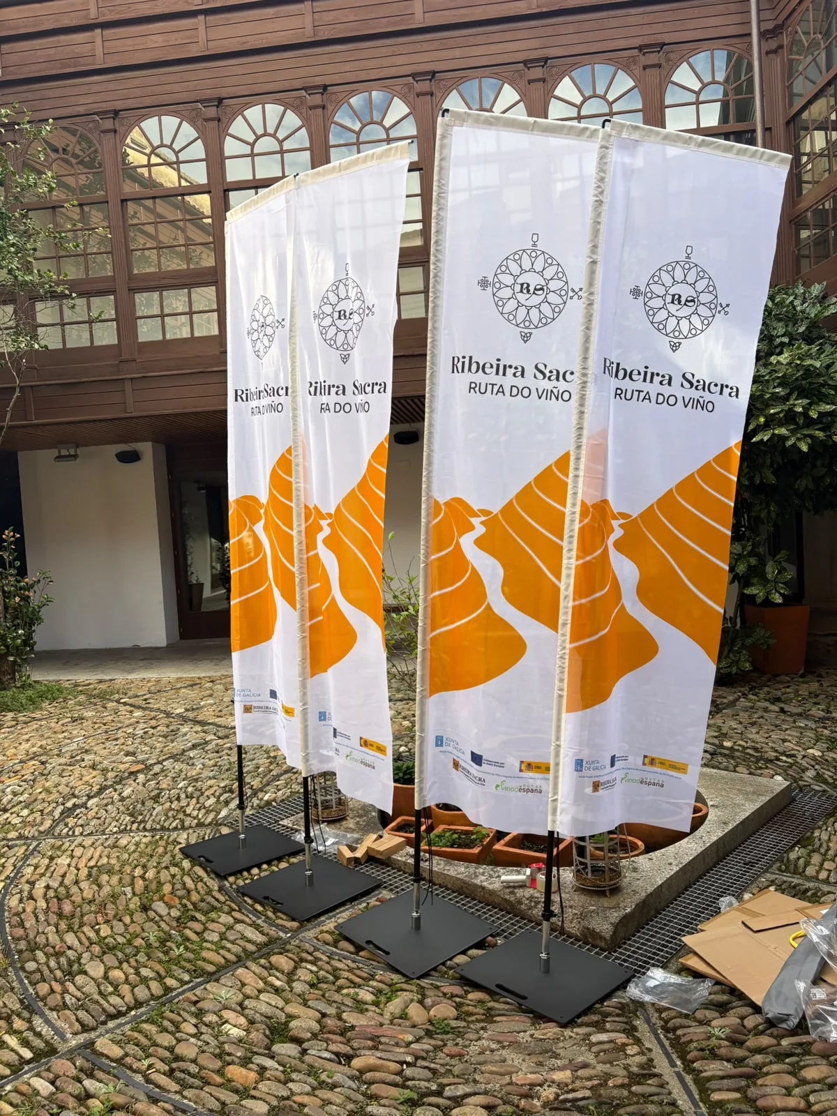 Banderas para exterior de la Ruta del Vino Ribeira Sacra con logotipo y bancales amarillos sobre fondo blanco